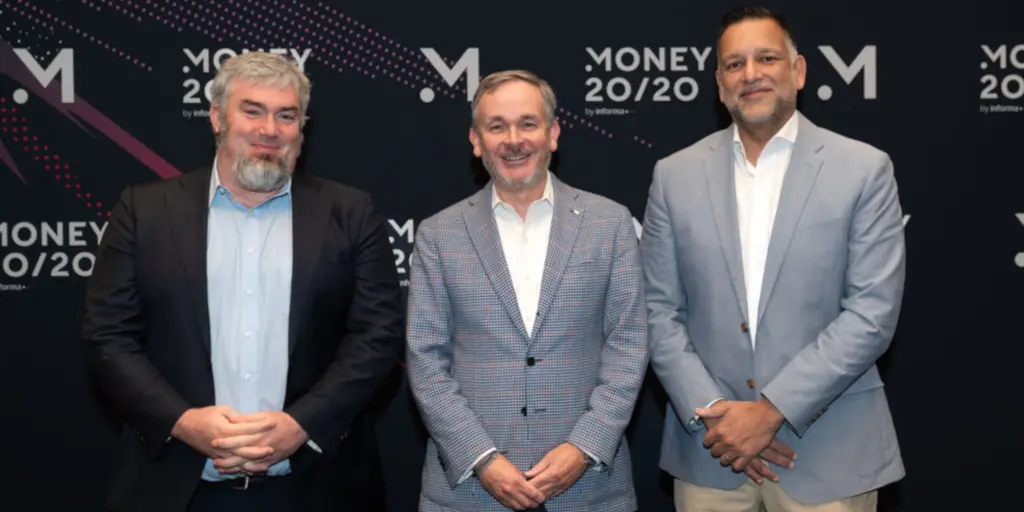 Three men standing in front of a backdrop at the Money 20/20 event.