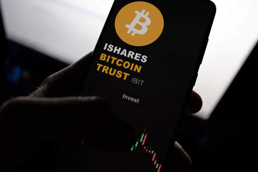 Close-up of a phone displaying iShares Bitcoin Trust investment interface.