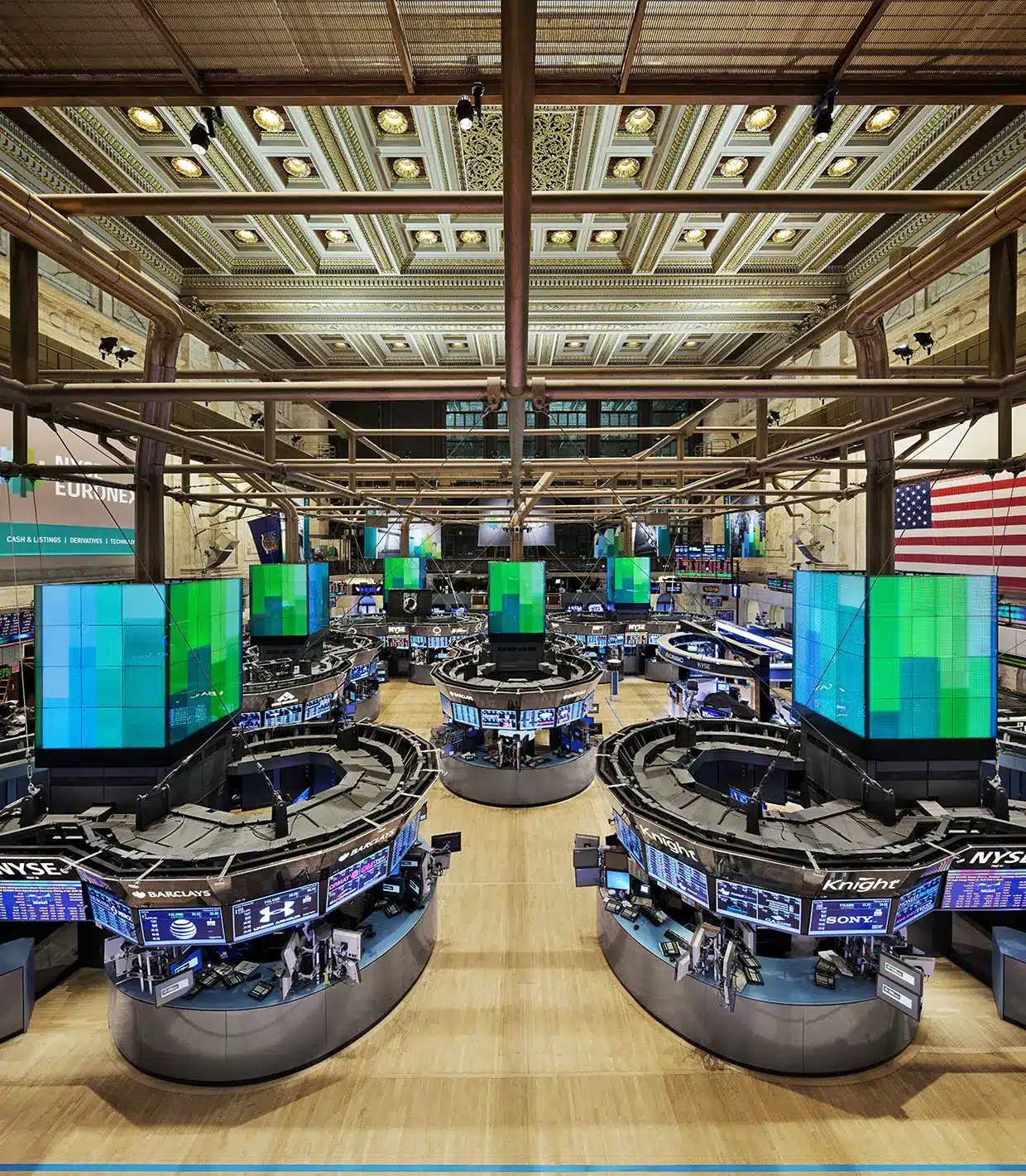 Wide view of New York Stock Exchange trading floor with screens and desks.
