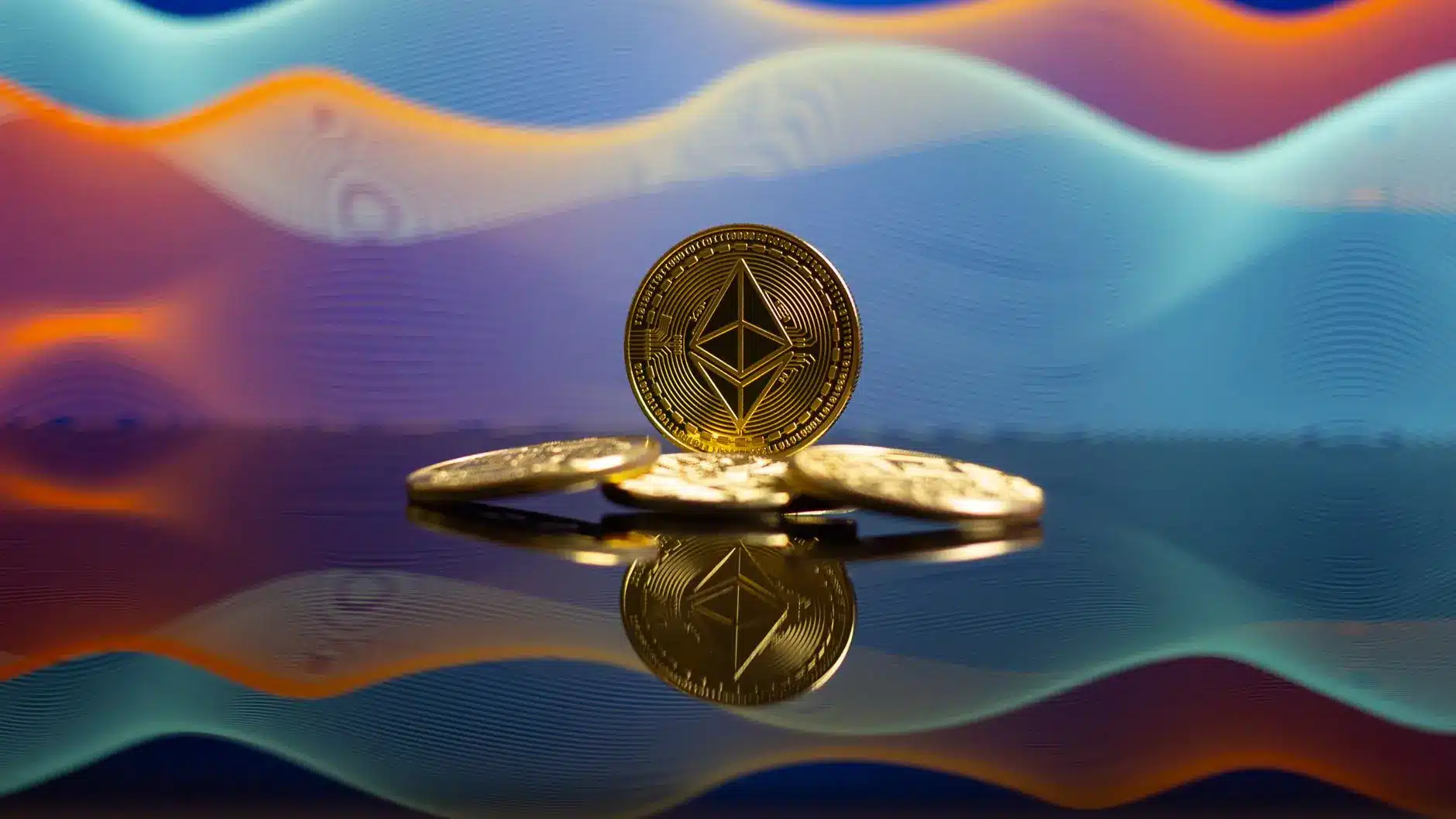 Gold physical Ethereum coins reflecting on a dark surface against a colorful abstract wave background