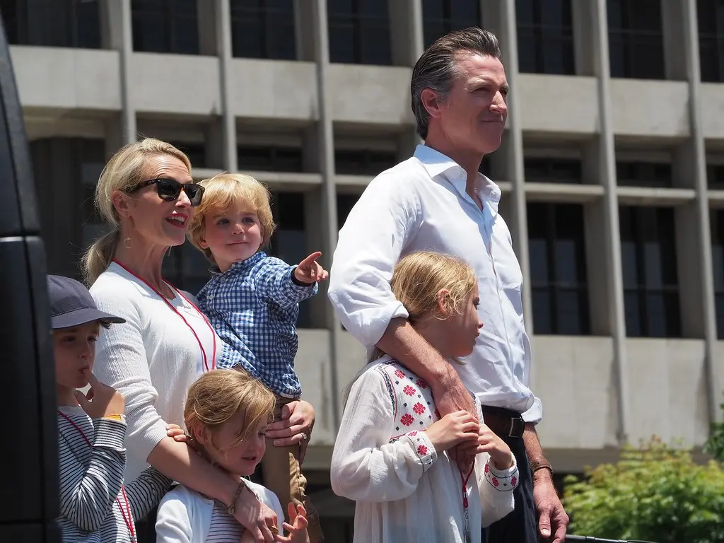 Gavin Newsom mit seiner Frau und seinen Kindern bei einer Veranstaltung im Freien.
