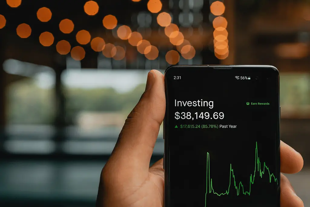 Ein Smartphone zeigt die Benutzeroberfläche der Robinhood-App mit einem Investment-Portfolio und einem Chart.