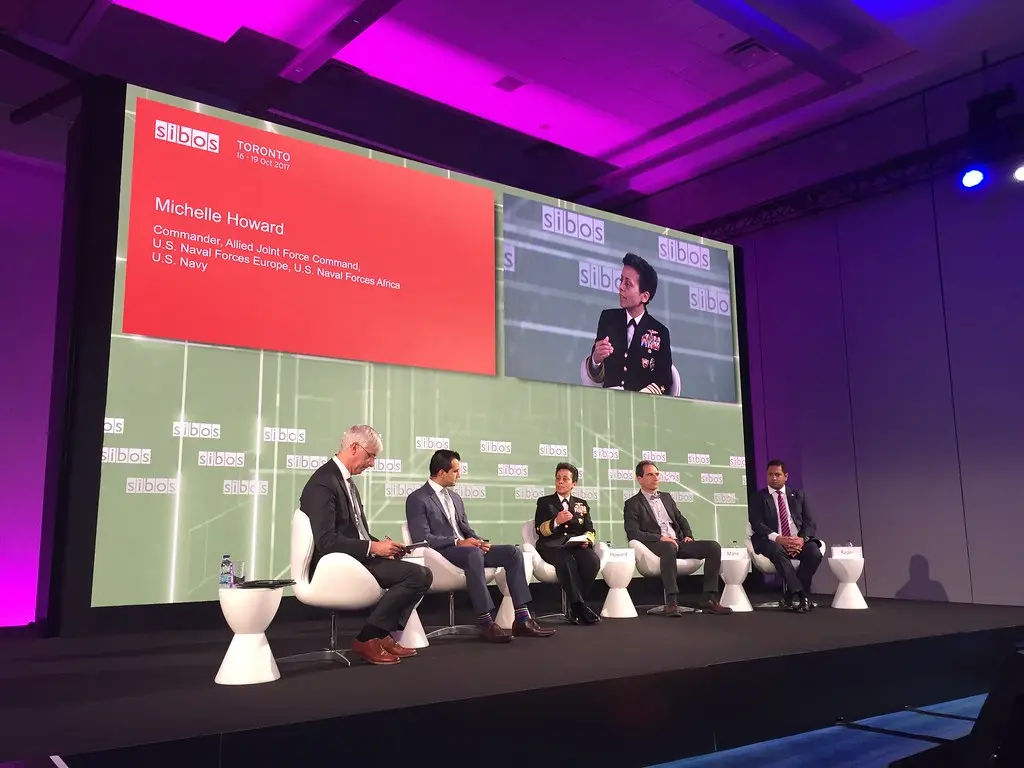 Eine Diskussionsrunde auf der Sibos-Konferenz in Toronto mit einem großen Bildschirm im Hintergrund.