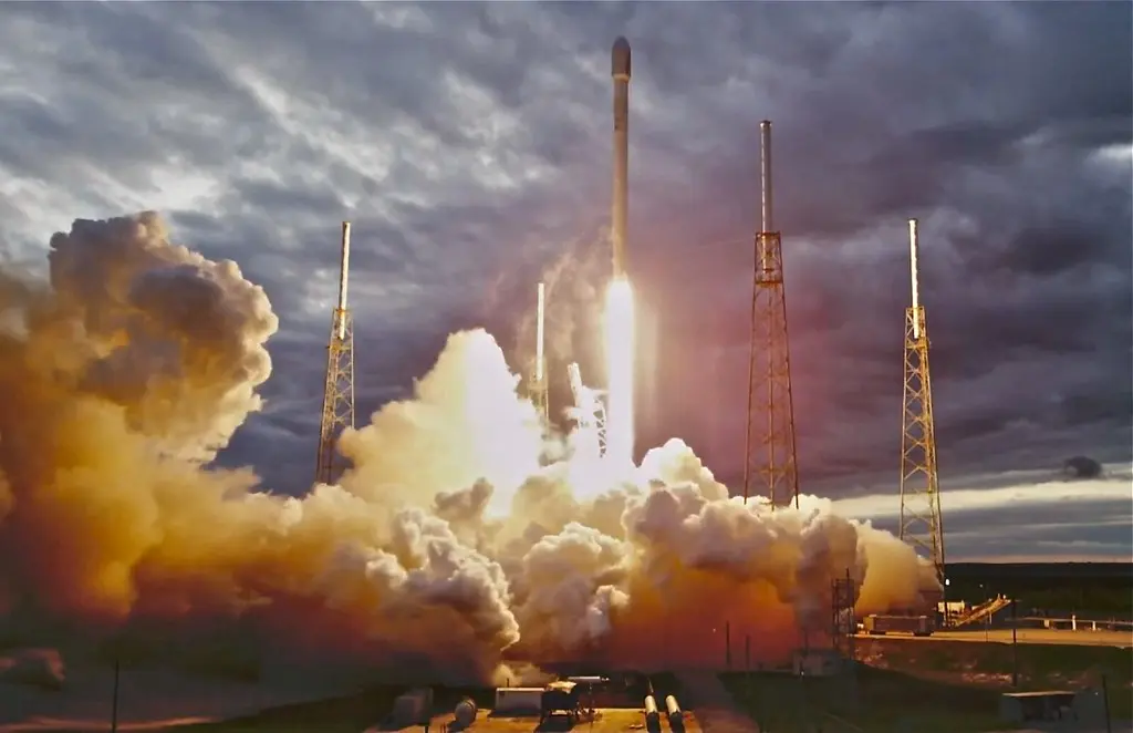 Eine SpaceX-Rakete hebt beim Start mit einer großen Rauch- und Feuerwolke ab.