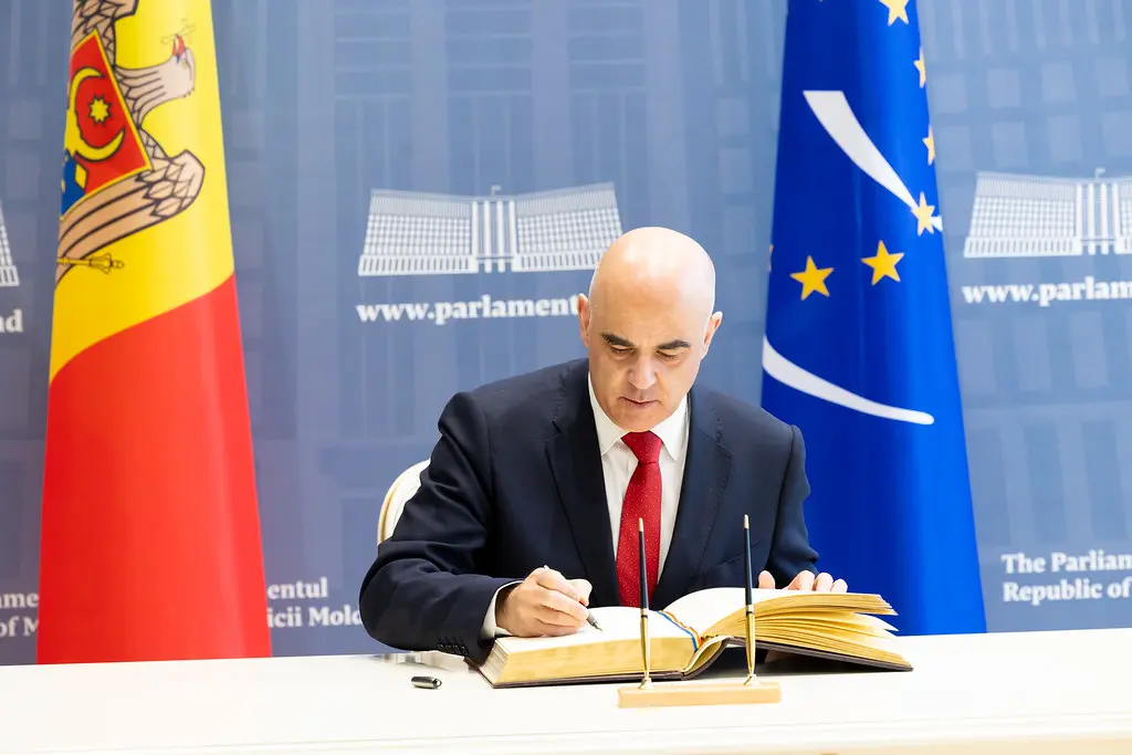 Alain Berset, Generalsekretär des Europarats, unterzeichnet ein Dokument.