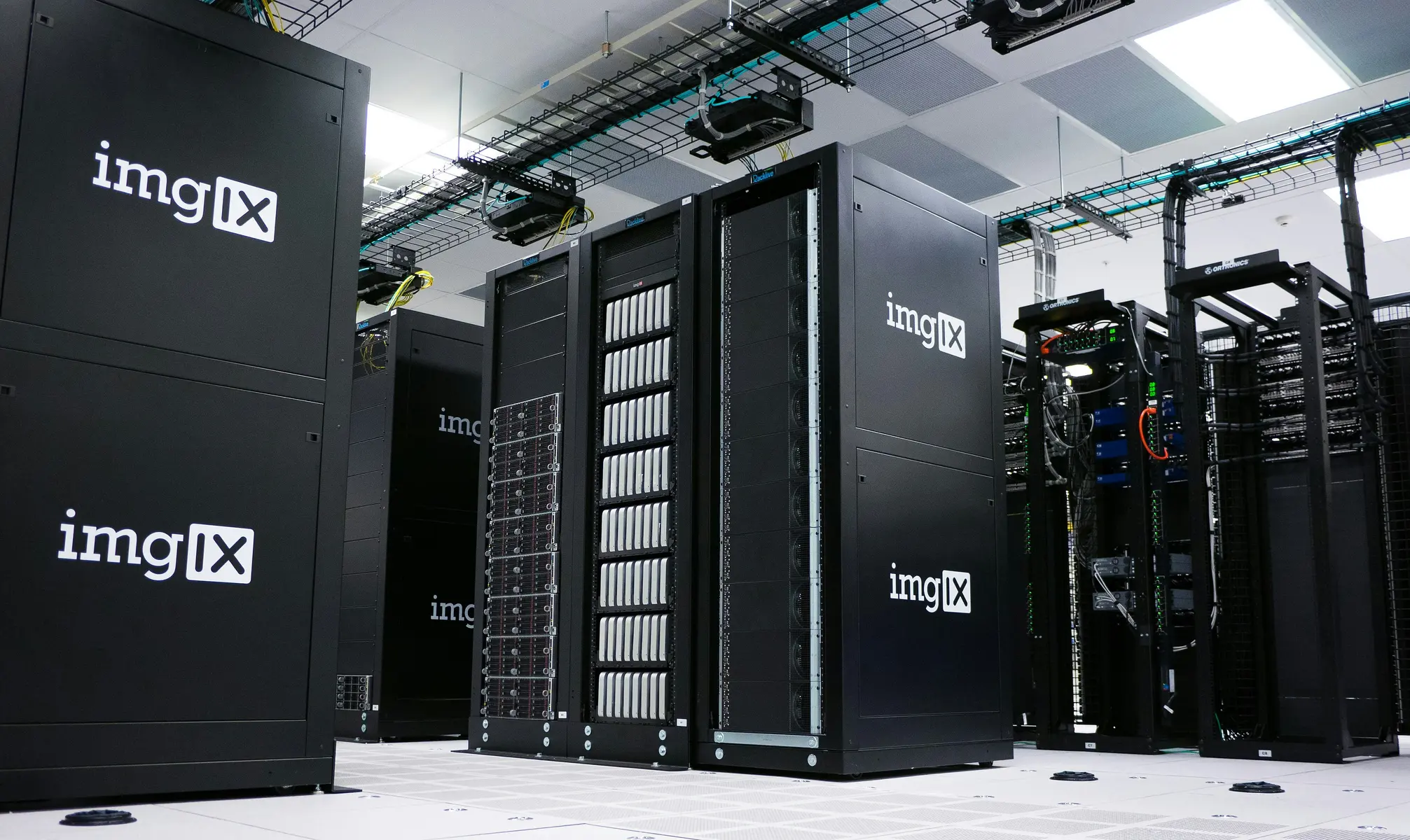 Mehrere schwarze Server-Racks in einem modernen, hell beleuchteten Rechenzentrum.