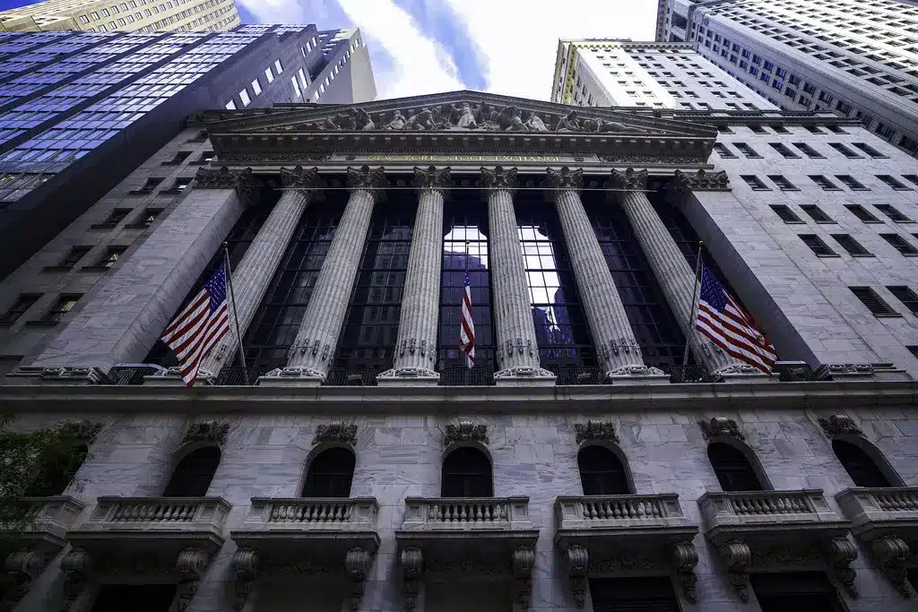 Weitwinkelansicht der Fassade des New York Stock Exchange Gebäudes mit korinthischen Säulen und US-Flaggen.