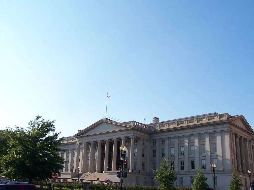 Das Gebäude des Finanzministeriums der Vereinigten Staaten in Washington, D.C. unter blauem Himmel.
