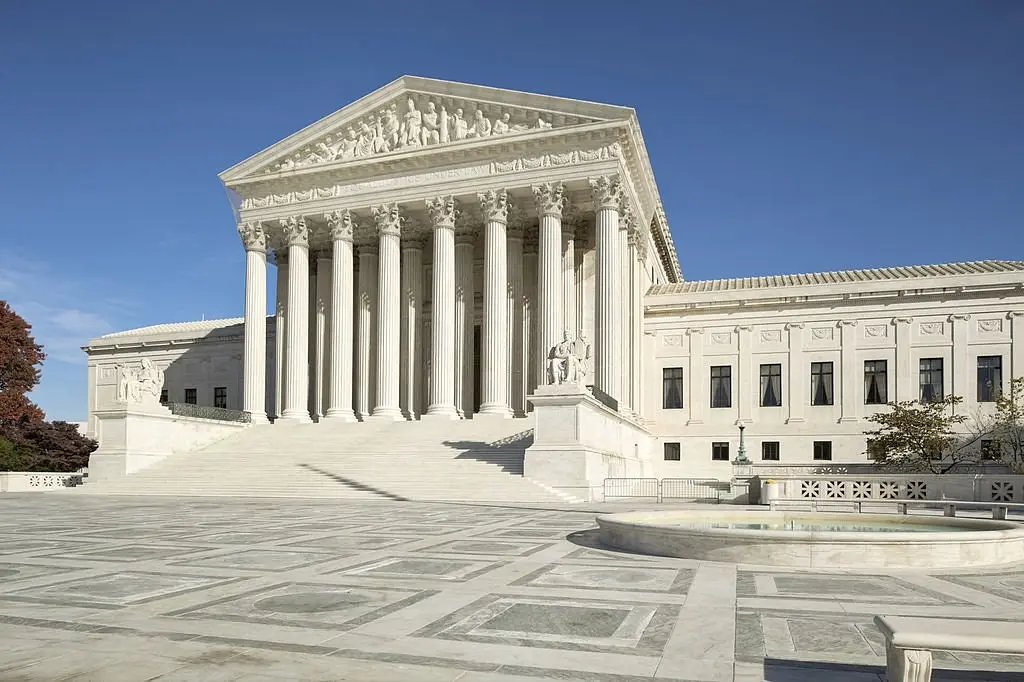 Het witte marmeren gebouw van het Amerikaanse Hooggerechtshof in Washington D.C. onder een blauwe lucht.